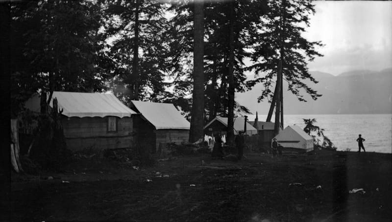 Campers' cottages and tents among the trees at the foot of Balaclava Street, above the water