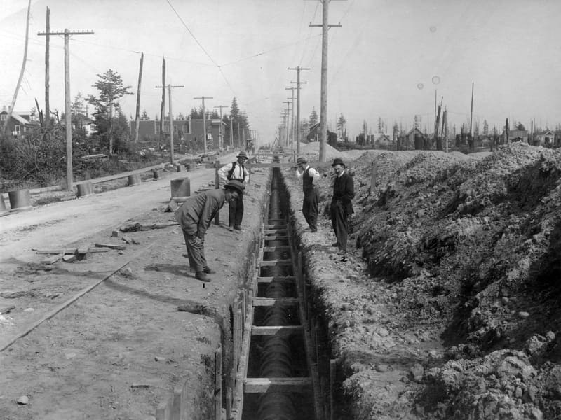 Men inspecting a new sewer trench along Wilson Road (41st Avenue), looking east from Elm Street