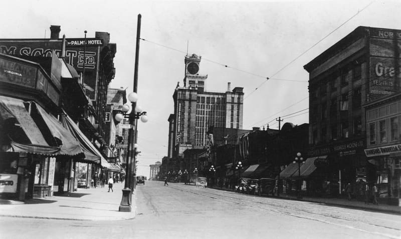 Shops, parked cars and a few people on the 800 block of Granville Street on a Sunday