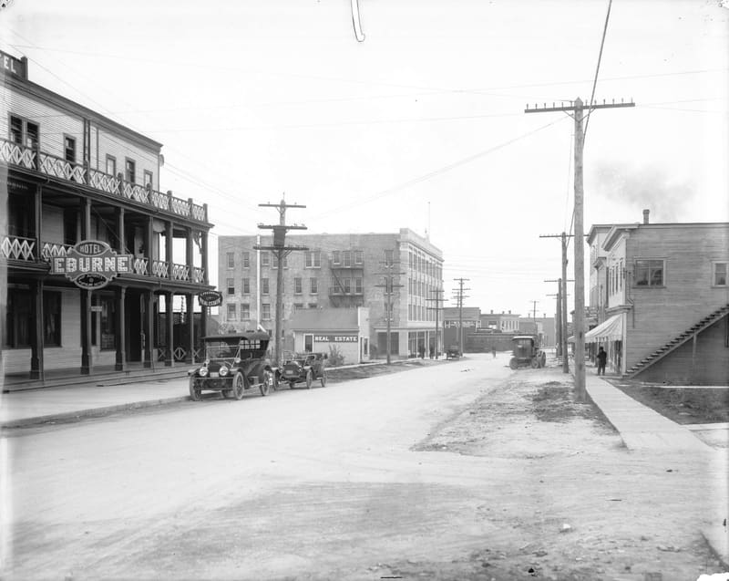 Hudson Street looking south toward the Eburne station, past the Hotel Eburne and parked cars