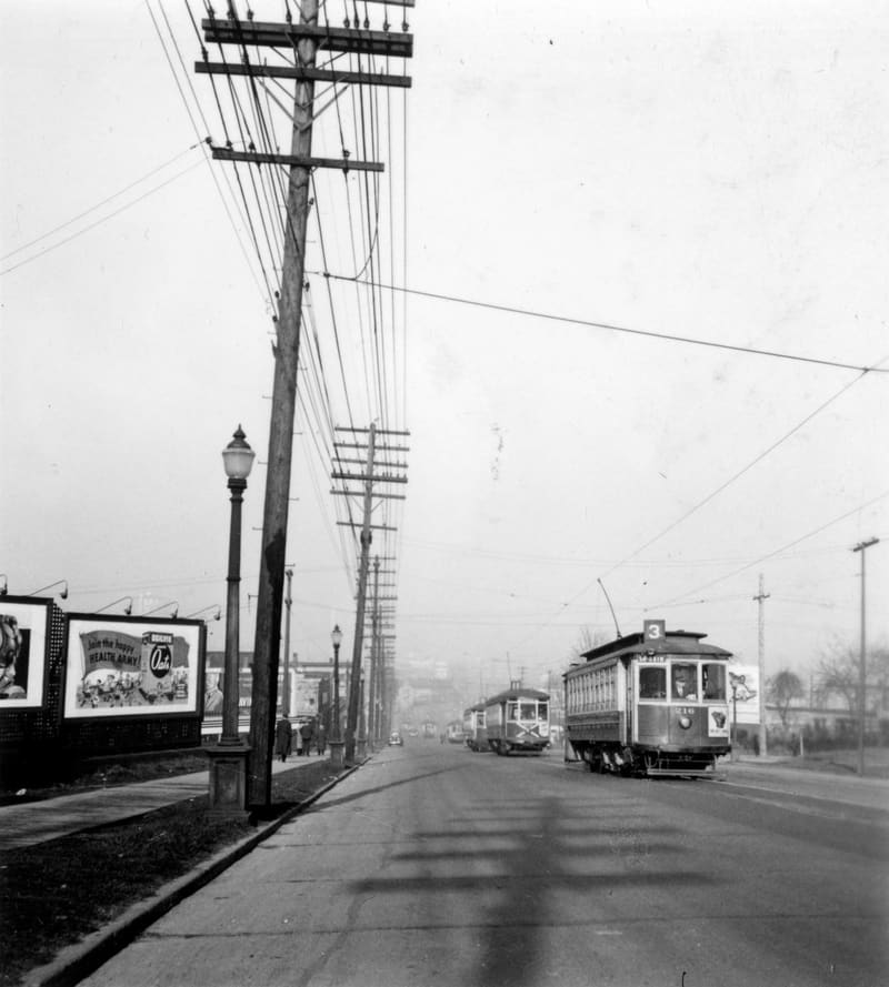 Streetcars on Main Street, past a row of billboards