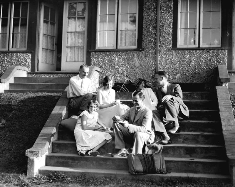 Friends taking tea on the front steps of P. Stewart's house at 2437 Point Grey Road