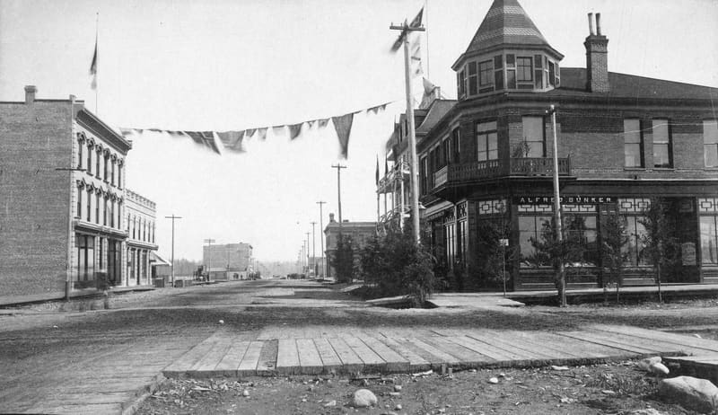 Hastings Street looking east from Granville on 1 July 1888, with flags strung across it and the Alfred Bunker building on the corner